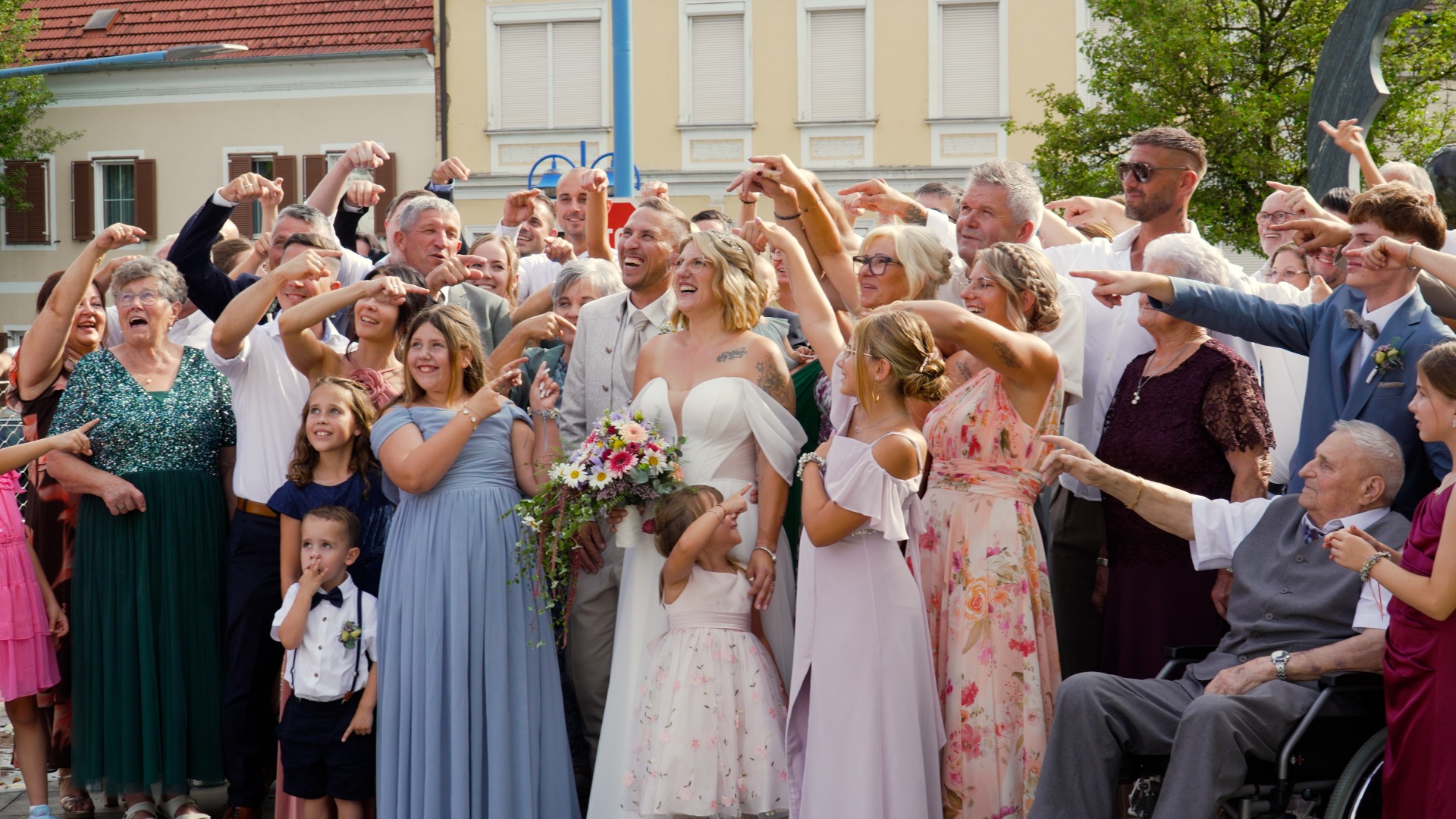Brautpaar lacht und feiert mit Familie und Freunden